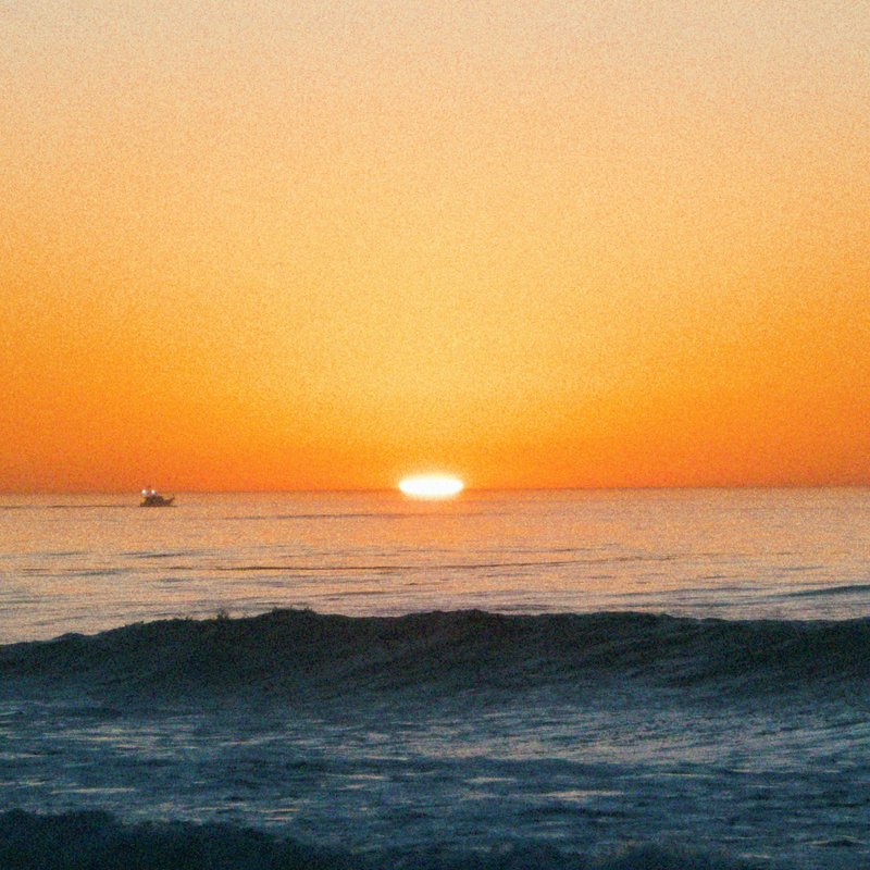 Songs of Adelina album artwork: sunset over ocean waves